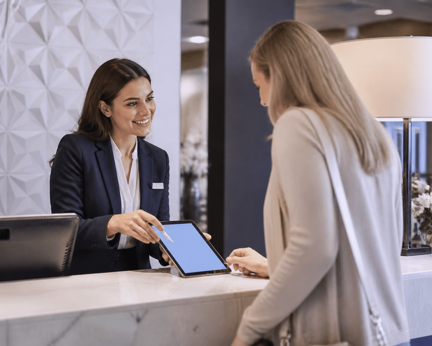 Hotel front desk staff collecting guest email consent on tablet during check-in with warm interaction